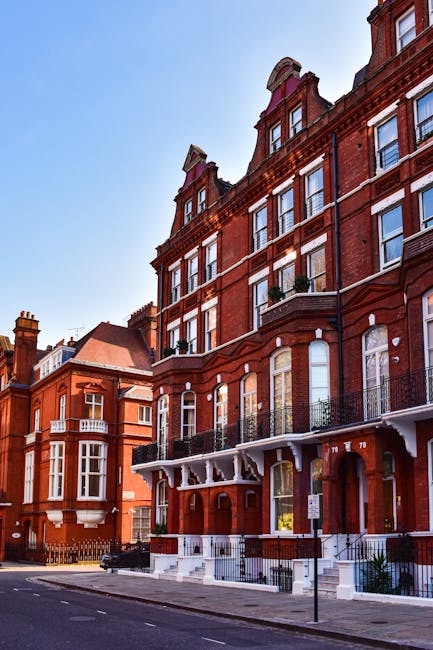 A multi-story brick building located on a street in West Kensington, with a distinctive architectural style featuring white accents around the windows and a small tower-like structure at the top. The